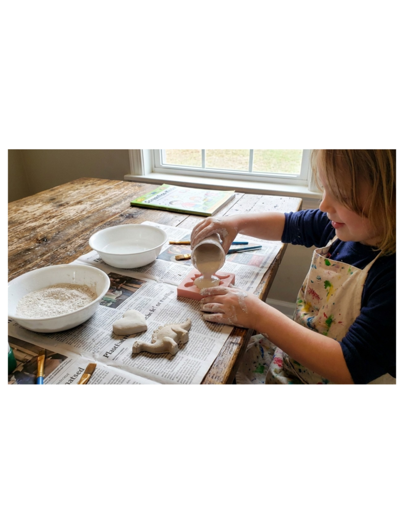 Kind sitzt am Spieltisch und Bastelt mit Gibs